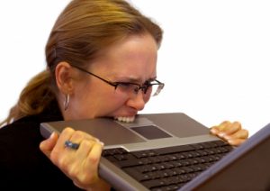 Image of a woman biting her laptop