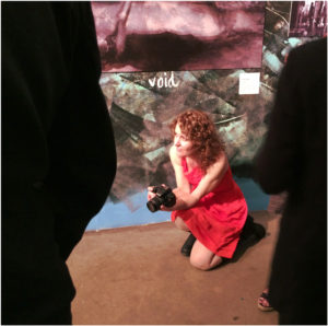 Tatiana Rivero Sanz kneeling in red dress on photo shoot in her studio— it is here that she took the photos for the collaboration with Japanese composer Aki.