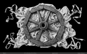 A black and white photograph of a wooden wheel on top of a canvas