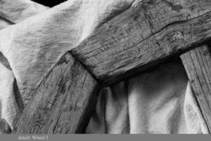 A close-up of a photograph of a wooden wheel with etchings in it