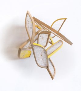 A wooden and glass abstract sculpture with certain portions painted yellow