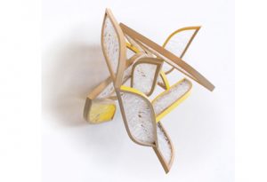 A wooden and glass abstract sculpture with certain portions painted yellow