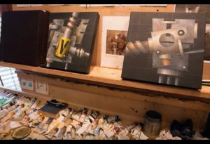 Paintings line the shelves of an architectural painter's studio