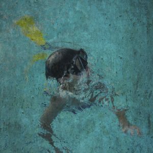 An edited digital photograph of a young boy in a pool