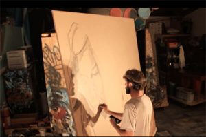 An artist working on a large-scale portrait