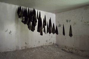 An installation of hanging canvas in an old army barracks