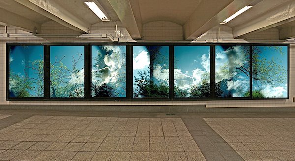 A multiple-exposure photograph along multiple panels at a subway station