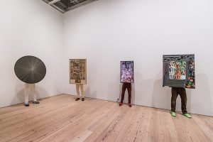 An installation of figures depicting artwork handlers