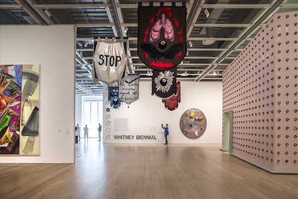 Banners hang along the ceiling at the entrance to the Whitney Biennial