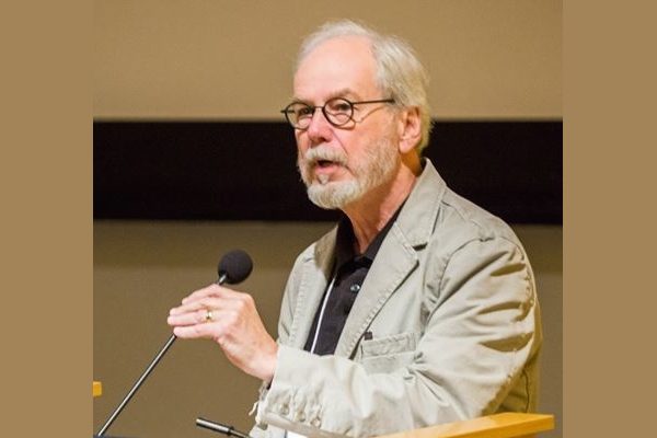 Writer Richard Hoffman stands at a podium giving a speech