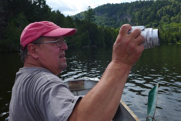 Artist Alan Bray takes a photograph from his canoe
