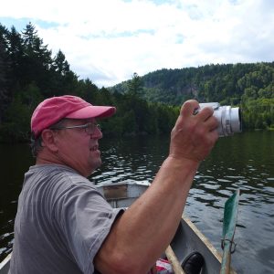 Artist Alan Bray canoes on a lake, taking photographs