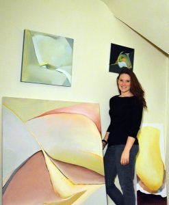 Artist Catherine Spencer poses with her paintings