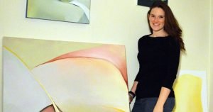 Artist Catherine Spencer poses with her paintings