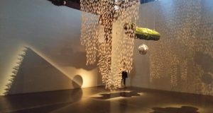An installation of plastic figurines hanging from the ceiling