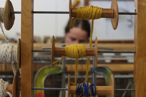 A photograph of artist Britta Fluevog working at her loom