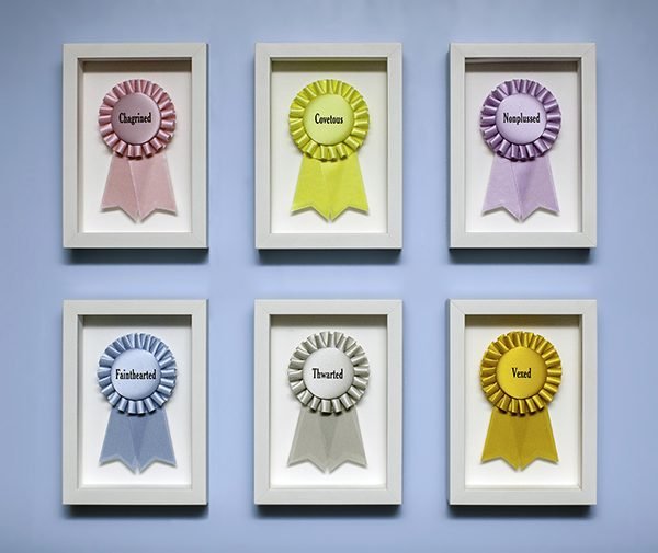 6 custom printed ribbons listing personality flaws that impede winning, framed in shadow boxes