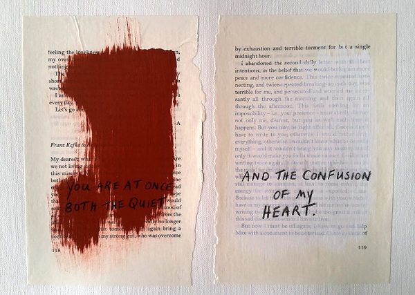 Ripped pages from a book with paint over the text, and new text written over