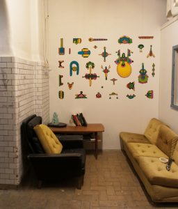 A collection of colorful textile figures arranged on a wall