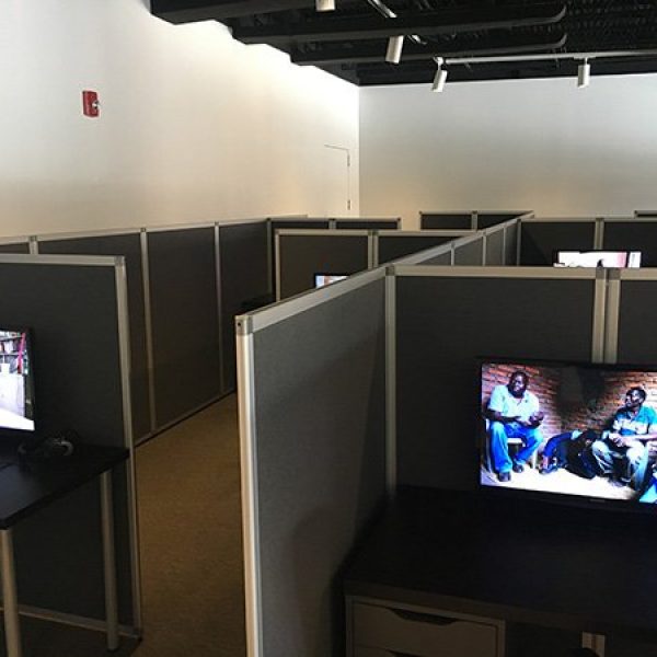 Multiple computer screens in individual cubicles as part of an art installation