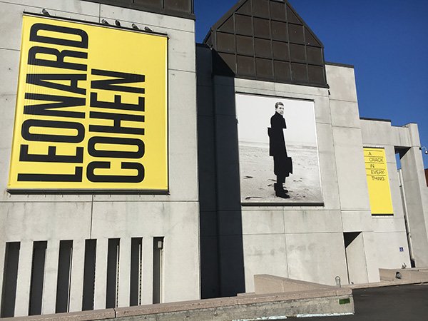 The outside of the Musee d'art contemporarain in Montreal with the Leonard Cohen exhibition advertised