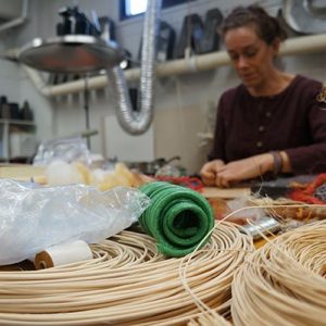 Fiber sits in the foreground of an image of an artist at work