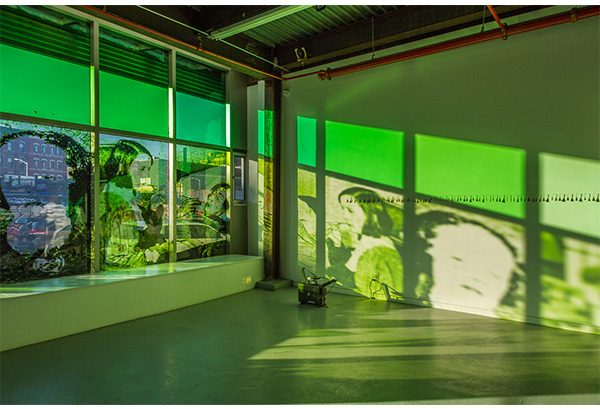 A piece of window projection art, green women on a wall