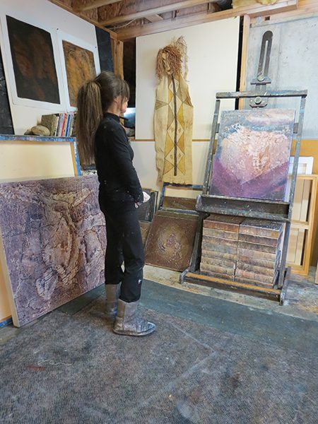 Josie Bell studies a painting in progress in her studio