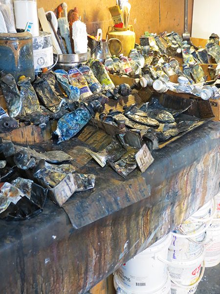 Tubes of paint lay on a table in an artist's studio