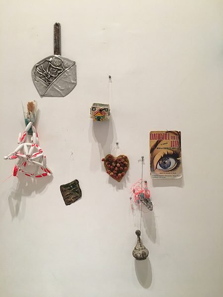 A collection of objects hung on the wall of a gallery