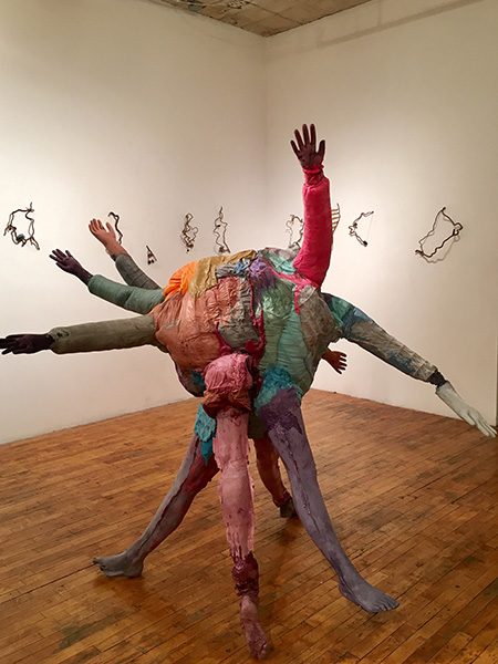 A sculpture made from painted mannequin hands and legs
