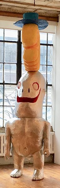 A paper mache sculpture of a humanoid figure wearing a top hat