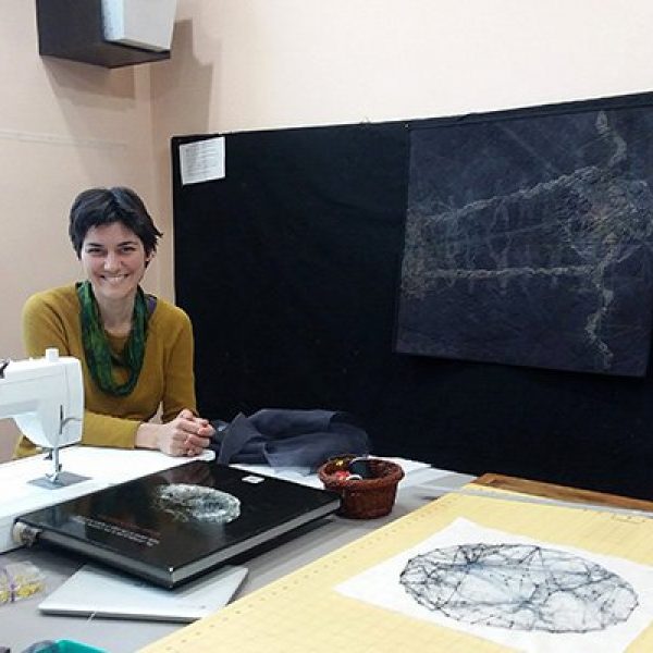 Quilting artist Shea Wilkinson in her studio with her sewing machine and works