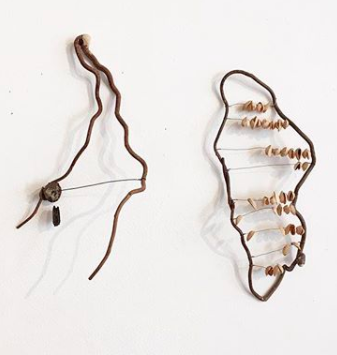 Instruments created from found material hang on a gallery wall