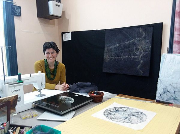 Quilting artist Shea Wilkinson in her studio with her sewing machine and works