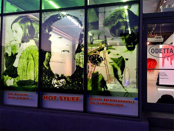 The storefront of a gallery with vinyl art on the walls