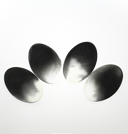 A black and white monotype of four ovals in an arc shape