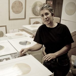 A sepia toned picture of an artist in her studio