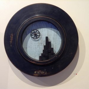 An installation of the view from a physical porthole hangs on a gallery wall