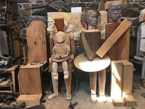 Wooden dolls and sculptures sit in Susan Clinard's studio