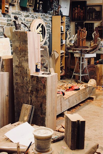 Wooden sculptures and works in progress in the corner of an artist's studio