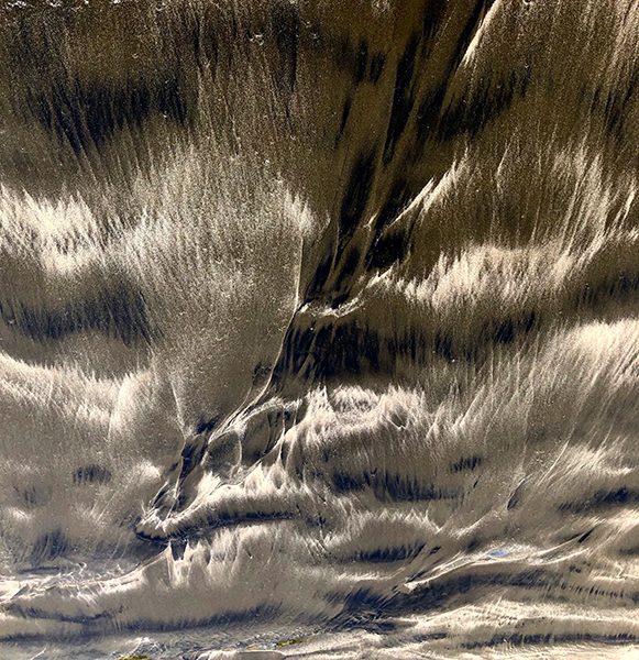 An abstract, sepia-toned photograph of sand