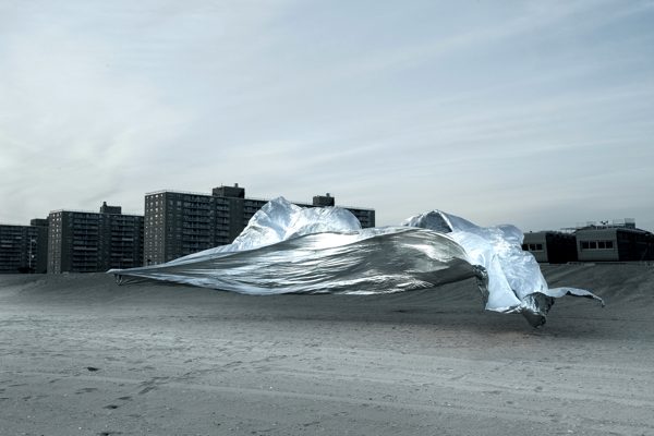 A photograph of a silver sheet floating above a Long Island beach