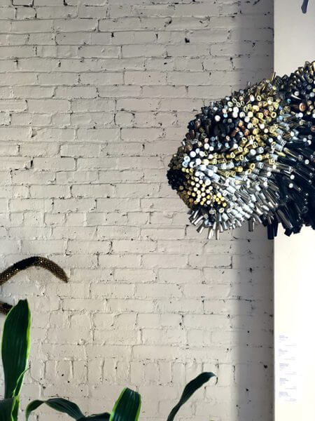 A mounted lion head made from colored plastic tubing