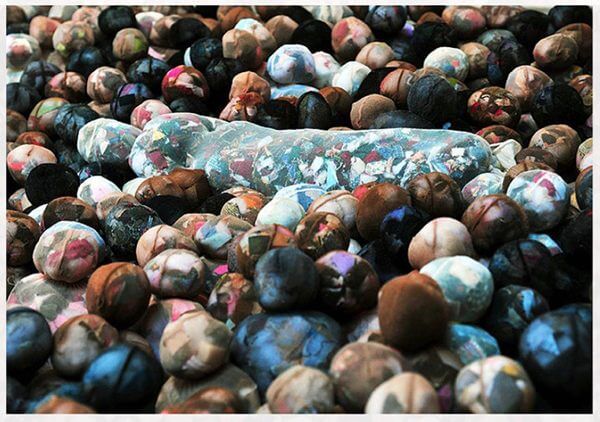 A photograph of a group of fabric figures arranged as if gathering around a casket