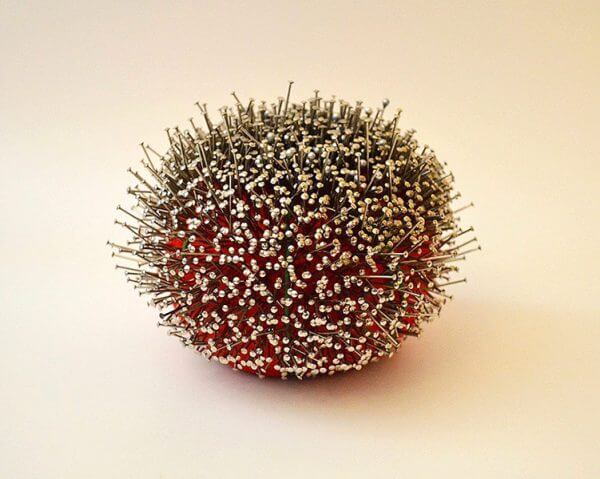 A pincushion stabbed entirely with pins