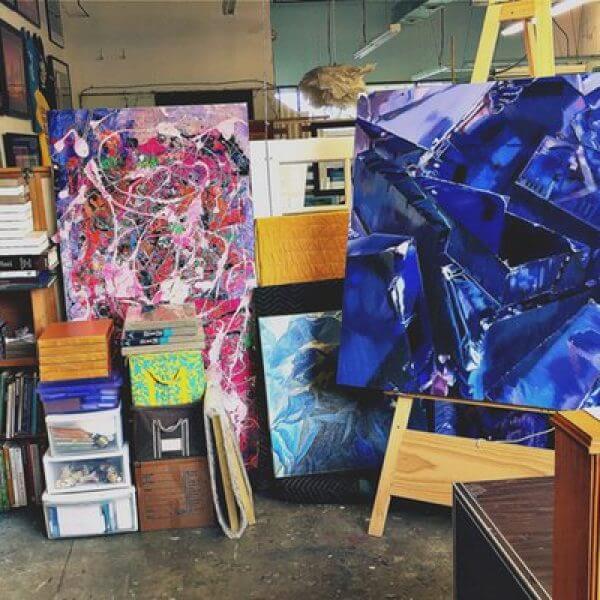 Large close-up paintings of flowers and crystals in an artist's studio