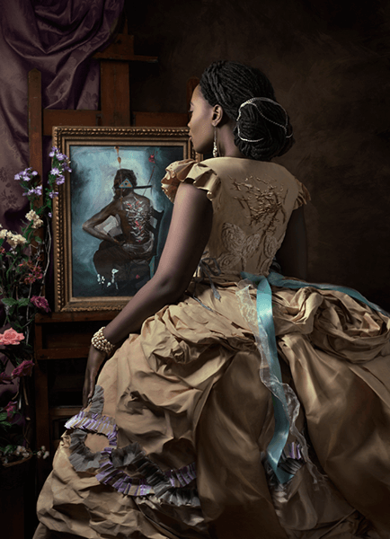 A photograph of a woman in an ornate dress looking at a painting of herself