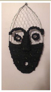 A face made from synthetic black hair woven through chicken wire