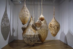 An installation of hanging vessels made from homemade paper